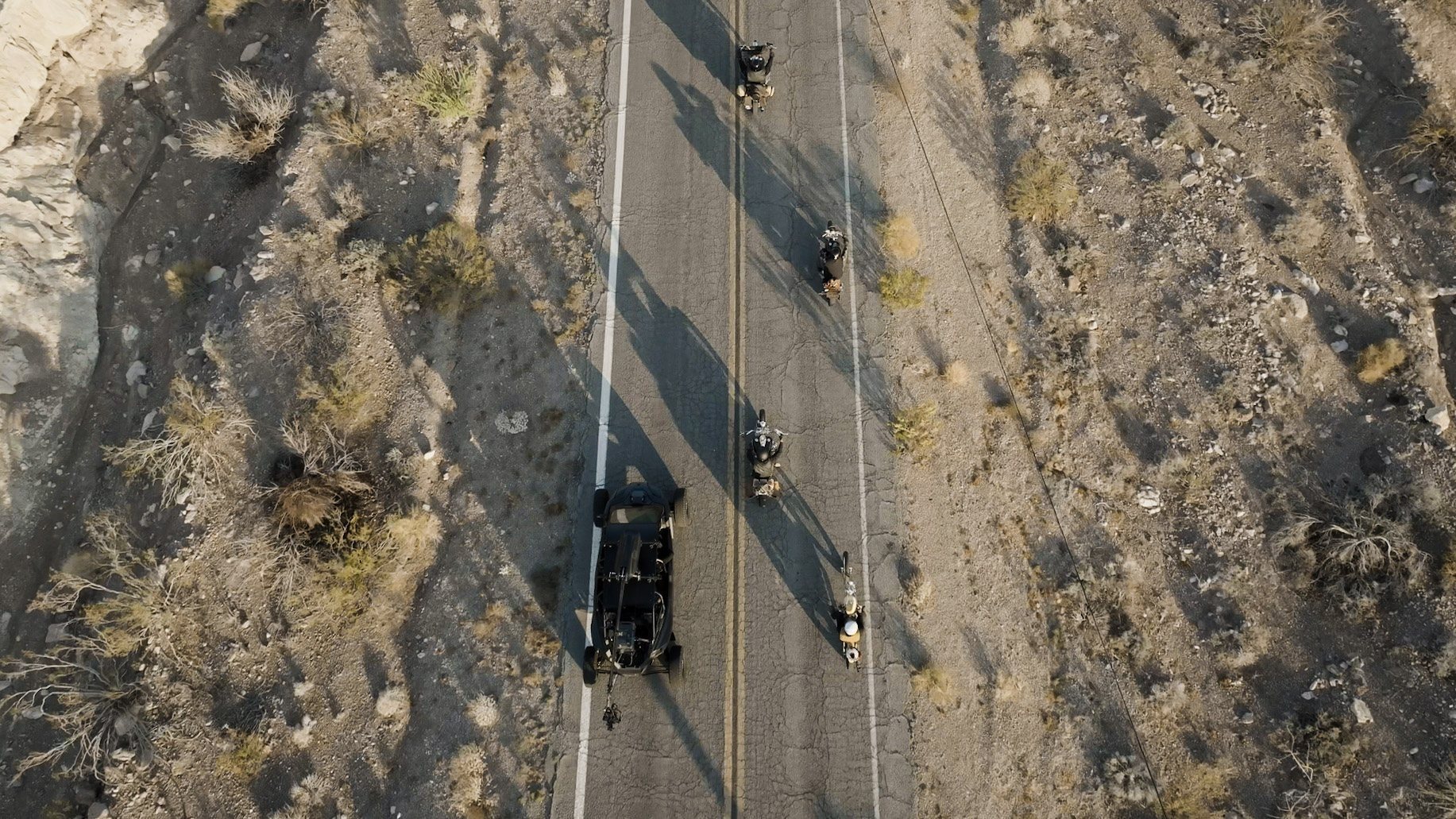 Top-down aerial of riders on a desert road