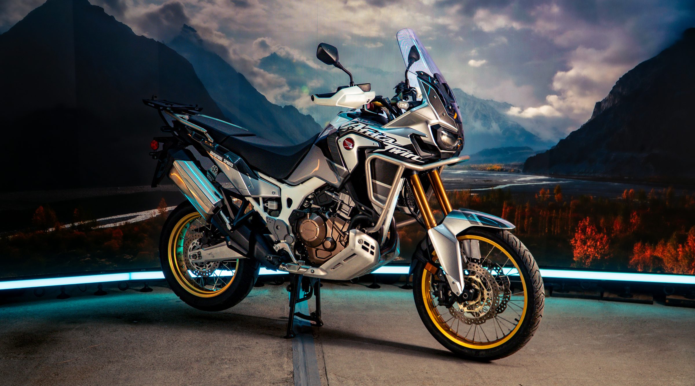 Adventure motorcycle on the LED stage against a mountain backdrop