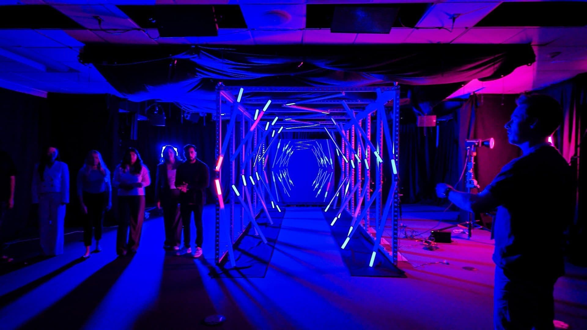 Crew walking through a tunnel of LED light bars