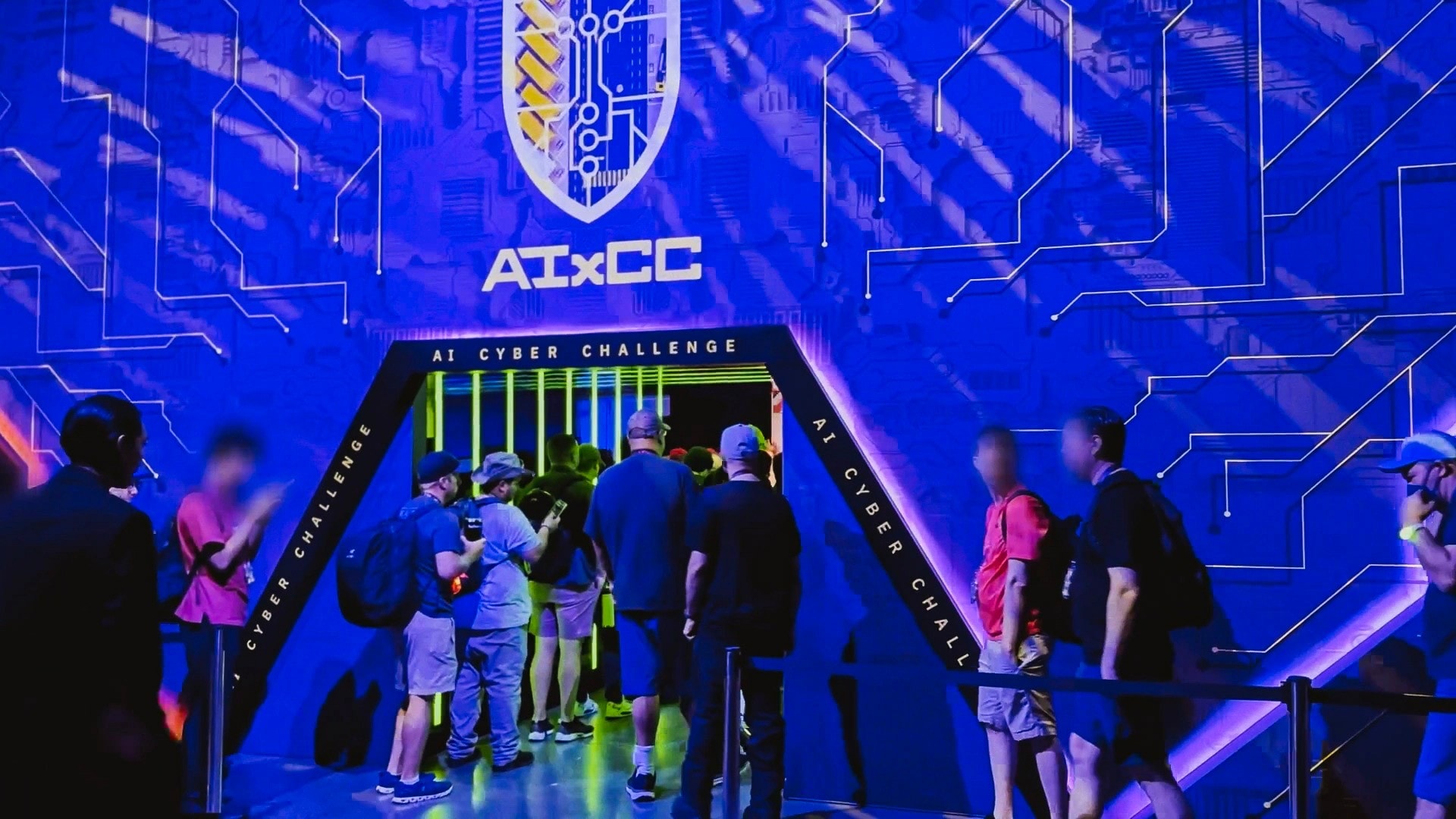 Visitors gathering at the AIxCC exhibit entrance under blue light