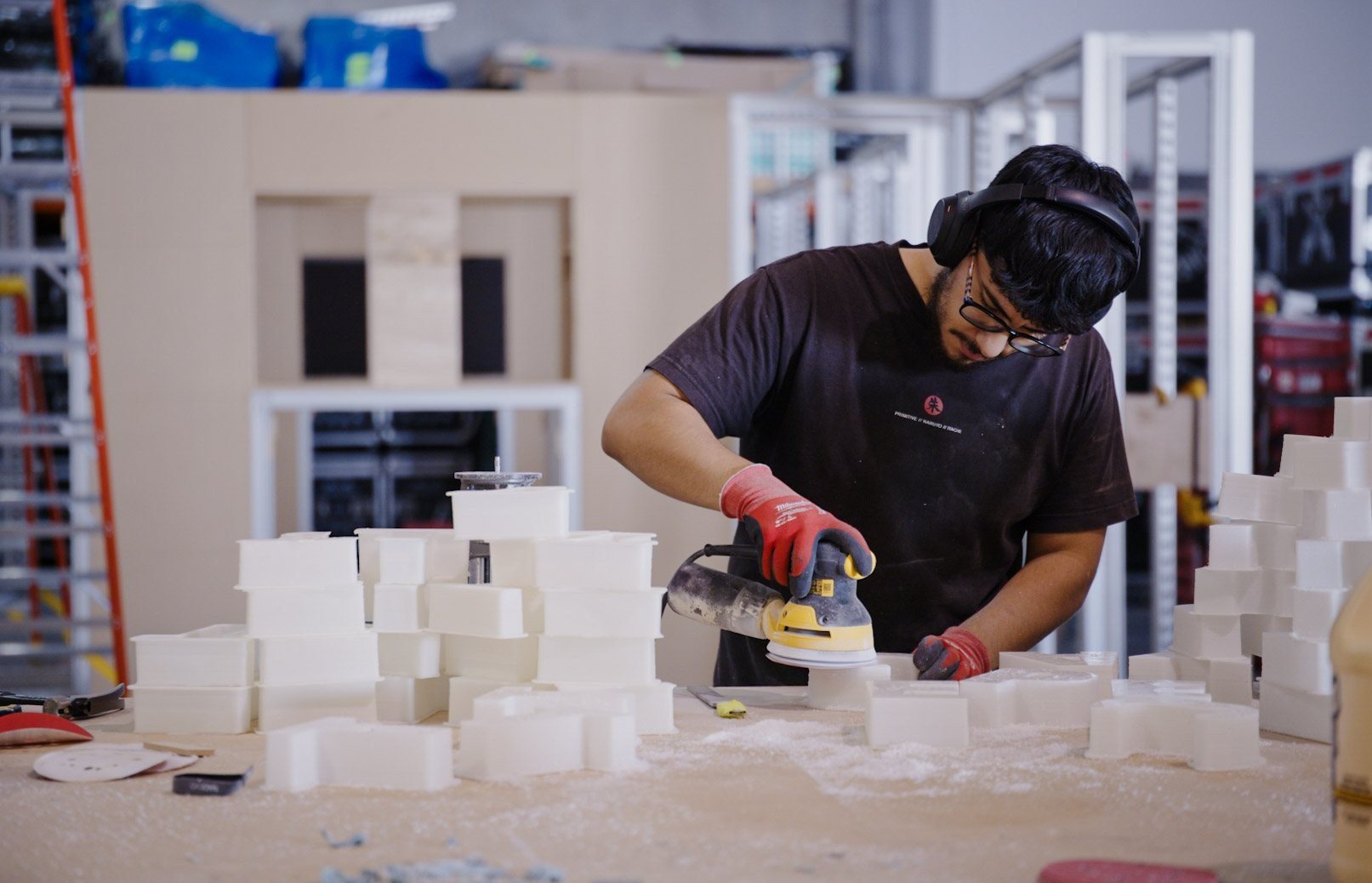 Fabricator sanding foam blocks in the build shop