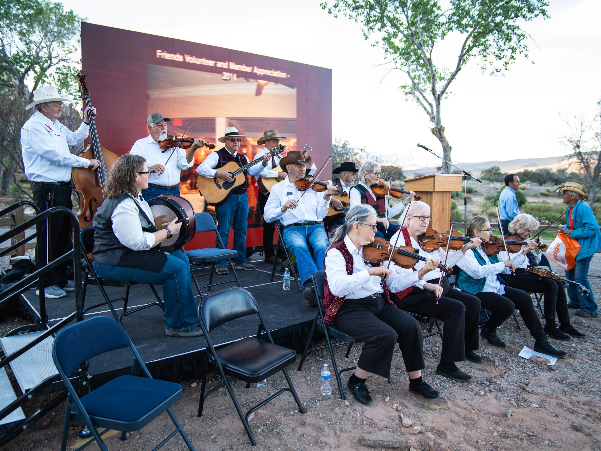 Bluegrass fiddlers and guitarists playing on the outdoor stage
