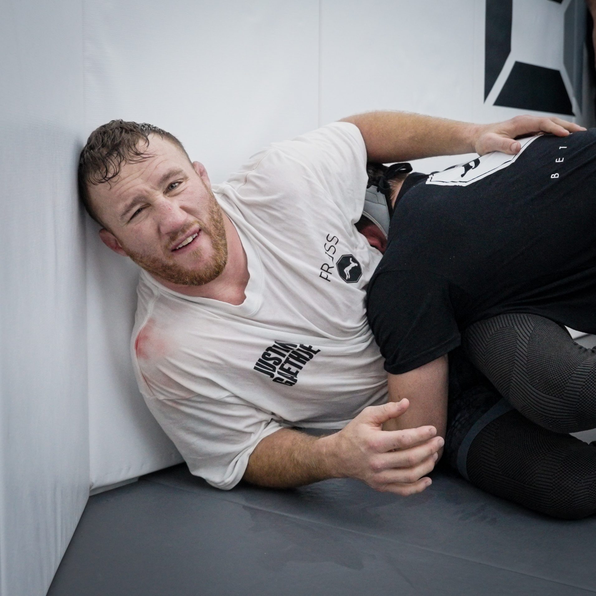 Gaethje laughing on the mat mid-grapple