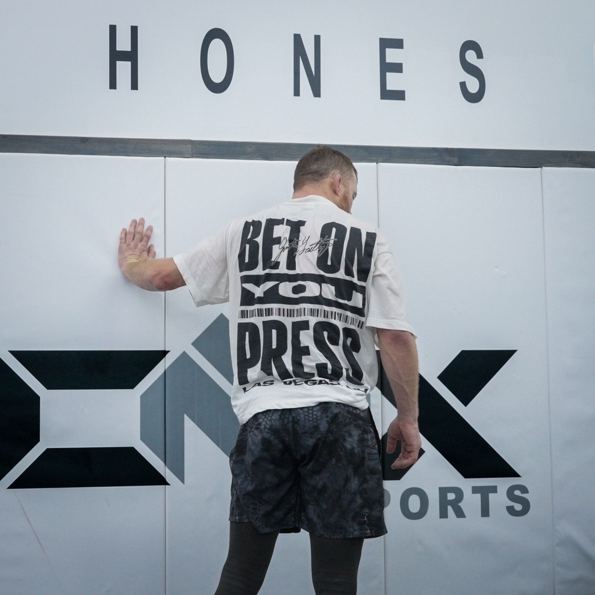 Gaethje's "Bet On You Press" shirt from behind against the ONX Sports wall