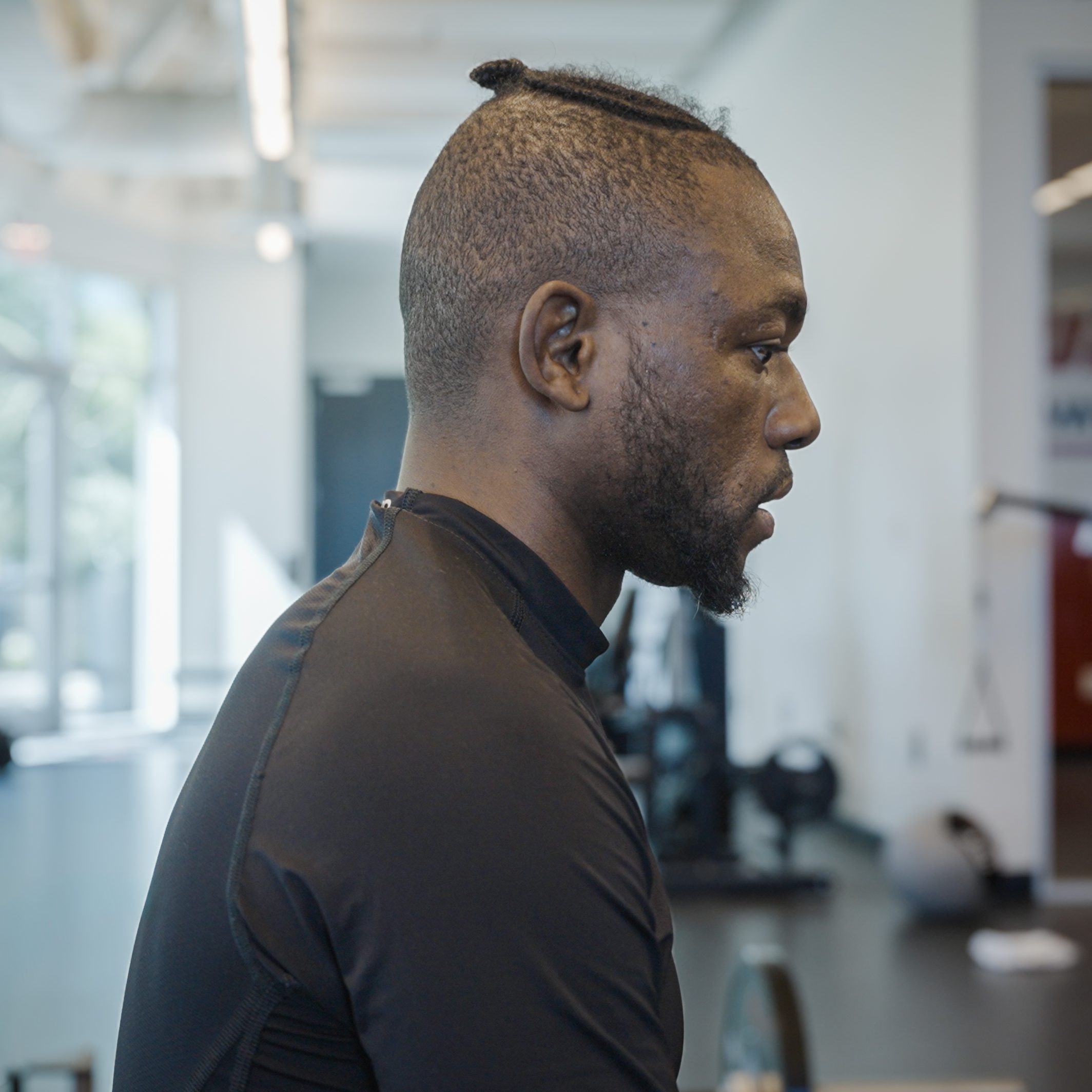 Manel Kape in profile in a black training top at the gym