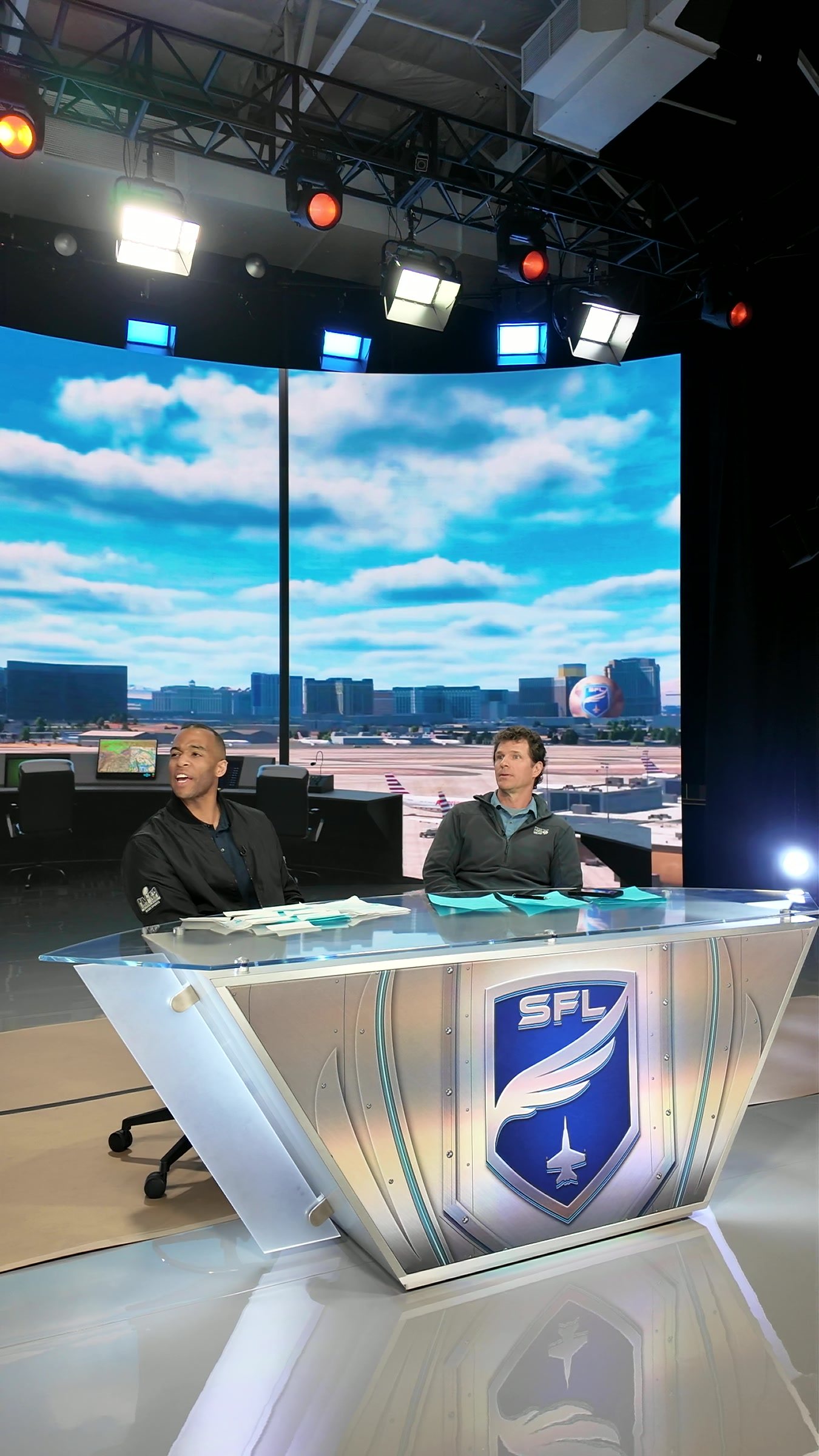 Hosts at the SFL desk under the XR sky, vertical