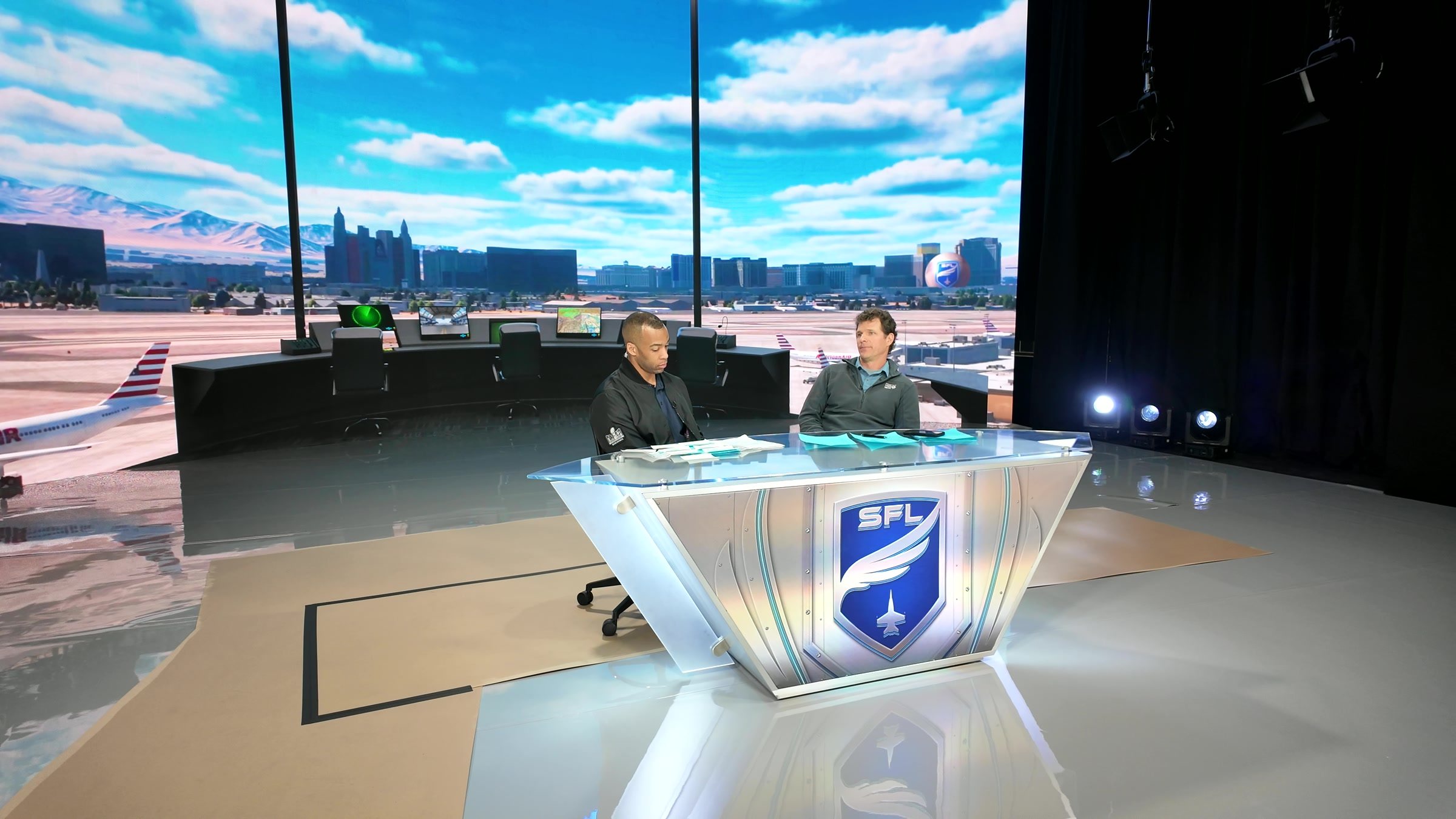 The SFL desk and its two hosts on the XR stage, seen from the floor